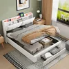 A bedroom scene with a white bed as the main focus, featuring storage compartments and LED lighting. Produktbild-Vorschau