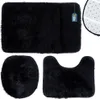 A set of three black bath mats, including a rectangular mat, a toilet seat cover, and a U-shaped mat. Produktbild-Vorschau