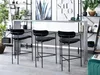 Three black bar stools are placed in front of a bar counter in a modern interior setting. Produktbild-Vorschau