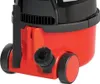 Close-up view of the lower section of a red and black vacuum cleaner, showing a brush attachment and wheels. Produktbild-Vorschau