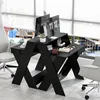 A modern black desk with a monitor riser, set up in a bright office or home setting with large windows. Produktbild-Vorschau