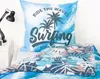 A bedding set with a pillow and duvet cover, featuring a tropical and surfing theme, displayed on a bed next to a bedside table with a lamp. Produktbild-Vorschau