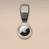 A golden Apple AirTag holder with a keychain attachment, shown against a plain beige background. Produktbild-Vorschau
