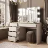 A makeup vanity and stool in a room with large windows. Produktbild-Vorschau