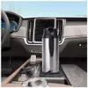 A portable electric kettle is shown inside a car's center console, with steam rising from a cup placed in front of it. Náhled obrázku produktu