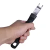 A hand holding a grill grate lifter tool. Voir les images du produit