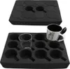 Two black foam inserts with multiple circular cutouts designed to hold cups or glasses. The bottom insert shows a clear glass and a white mug with a spoon. Podgląd zdjęcia produktu