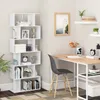 A white bookshelf with 6 compartments is filled with books and decorative items, placed in a room next to a desk with a chair. Produktbild-Vorschau