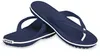 A pair of navy blue Crocs flip-flops with white trim and white branding on a white background. Produktbild-Vorschau