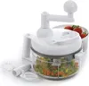 A white manual food chopper with a clear container filled with chopped vegetables, and a basket of strawberries in the background. Náhľad obrázku produktu