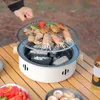 A person is grilling food on a portable charcoal grill outdoors. Anteprima dell’immagine prodotto