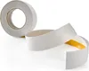 A roll of white adhesive tape and a section of the tape unrolled, showing the yellow adhesive side. Anteprima dell’immagine prodotto