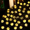 A string of warm white solar-powered LED lights with spherical bulbs, likely used for outdoor decoration. Voir les images du produit
