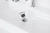 A close-up shot of a sink drain with water flowing into it. Podgląd zdjęcia produktu