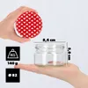 A hand holds a red lid with white hearts, while another hand supports a clear glass jar with dimensions indicated. Produktbild-Vorschau