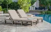 Two sun loungers with cushions are placed on a patio next to a swimming pool. Voir les images du produit