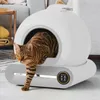 A cat is exiting an automatic cat litter box in a home setting. Podgląd zdjęcia produktu