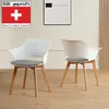 Two white chairs with wooden legs and black and white patterned cushions are shown in a room. Produktbild-Vorschau