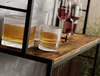 A close-up shot of whiskey glasses and a decanter filled with amber liquid, placed on a rustic wooden shelf. Podgląd zdjęcia produktu