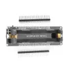 A black electronic development board with gold connectors and text labels, shown from a top-down perspective on a white background. Two sets of black pin headers are placed above and below the board. Produktbild-Vorschau