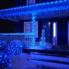 A house decorated with blue LED icicle lights and a light-up snowman for Christmas. Produktbild-Vorschau