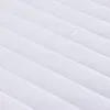 A close-up view of a white quilted mattress pad. Produktbild-Vorschau