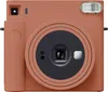 A front-facing studio shot of a Fujifilm instax SQUARE SQ 1 camera in terracotta orange. Anteprima dell’immagine prodotto
