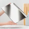 Hands holding a rectangular metal baking sheet. Anteprima dell’immagine prodotto