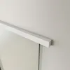 A close-up view of a frosted glass sliding door with a white frame, mounted on a white wall. Produktbild-Vorschau