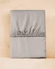 A folded fitted sheet is placed on a wooden surface. Anteprima dell’immagine prodotto