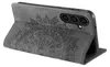 A close-up side view of a gray smartphone case with a mandala design embossed on it. The case is open, showing the back of a smartphone inside. Produktbild-Vorschau