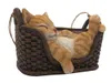 A decorative figurine of a sleeping cat in a woven basket. Produktbild-Vorschau