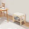 A wooden shoe bench with a cushioned seat and two shelves, placed in a room next to a wooden table and chair. Podgląd zdjęcia produktu