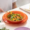 A person is eating a salad from an orange bowl. Produktbild-Vorschau