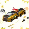 A golden toy car with a trailer, decorated with yellow festive elements and a small red graphic indicating action. Náhled obrázku produktu