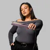 A woman holds a hair straightener in front of a plain background. Anteprima dell’immagine prodotto