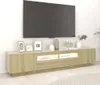 A modern, long, light wood TV stand with integrated LED lighting is displayed against a white wall. A large black television is mounted above it. Decorative items, including framed pictures, vases, and a sculpture, are arranged on top of the TV stand. Anteprima dell’immagine prodotto