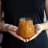 A person holding a jar of jam. Produktbild-Vorschau