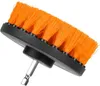A close-up, angled view of a drill brush attachment with orange bristles and a black base, mounted on a silver hexagonal shank. Podgląd zdjęcia produktu