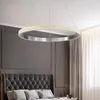A modern bedroom with a tufted headboard and a circular pendant light. Produktbild-Vorschau