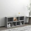 A gray bookshelf with multiple compartments, some of which are decorated with small items, placed against a light gray wall. Voir les images du produit
