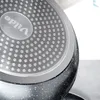 Close-up view of the bottom of a frying pan, showing the textured surface and branding. Anteprima dell’immagine prodotto