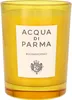 A yellow candle in a glass container with a white label. Produktbild-Vorschau