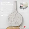 A light-colored pancake pan with animal shapes, featuring product feature callouts and branding. Voir les images du produit