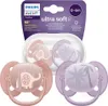 A package containing two Philips Avent pacifiers, one pink and one purple, with elephant and palm tree designs respectively. Produktbild-Vorschau