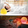 A split image showing a sunrise simulation alarm clock with a woman waking up and a sunset simulation alarm clock with a child sleeping. Produktbild-Vorschau