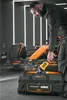 A man is putting a tool into a tool bag next to a race car. Produktbild-Vorschau