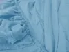 A close-up view of a light blue fitted sheet, showing the elasticized edge and fabric texture. Náhled obrázku produktu