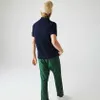 A person wearing a polo shirt and pants, shown from the back. Produktbild-Vorschau