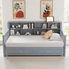 A gray daybed with built-in shelving and drawers, set against a wall with two framed art pieces. Náhled obrázku produktu